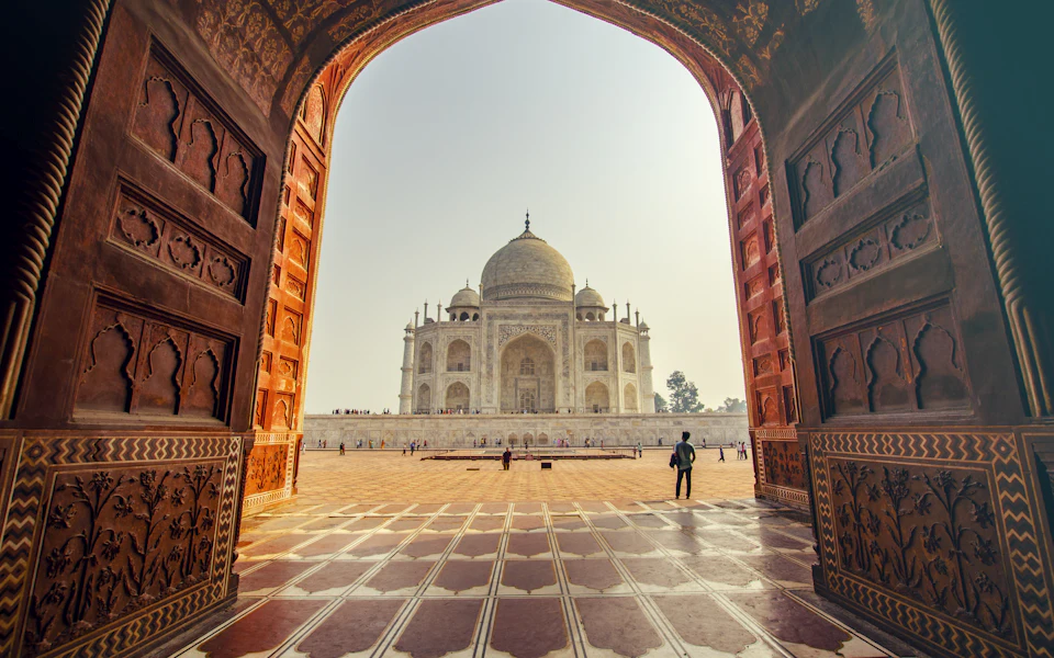 The Taj Mahal seen through a sandstone archway, India